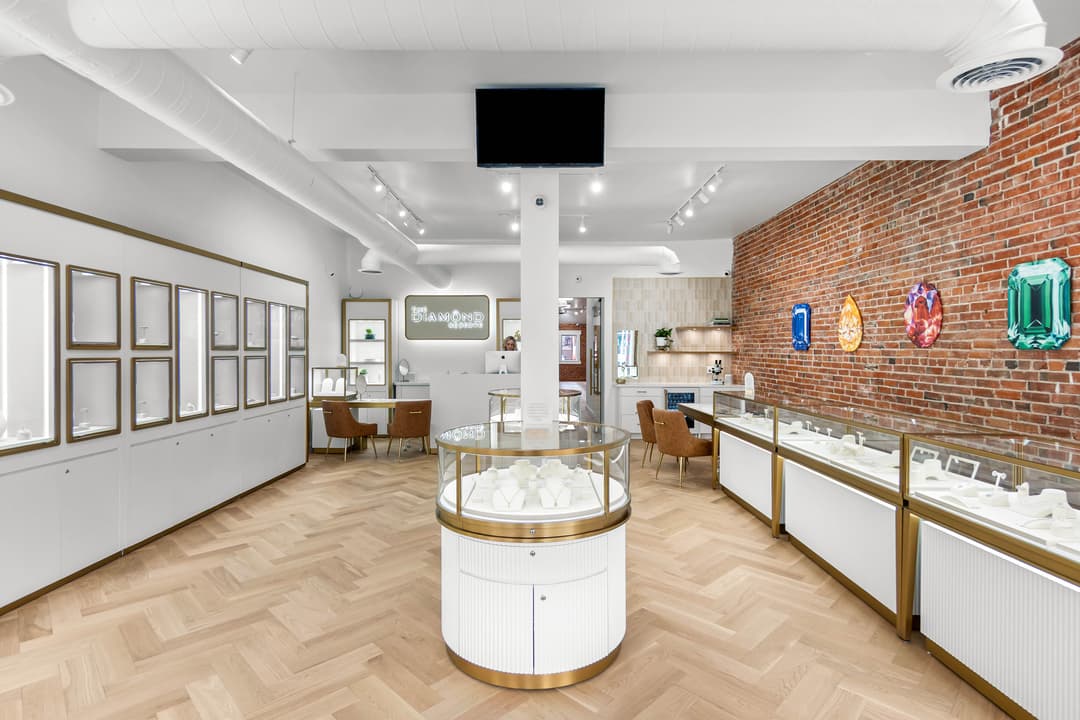 Elegant jewelry store interior with glass display cases and brick wall backdrop.