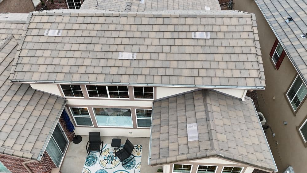 Aerial view of a modern home with a tiled roof and outdoor seating area.