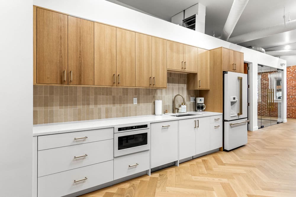 Modern kitchen with wooden cabinets, white countertops, and stainless steel appliances.